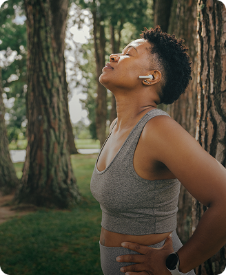 Person stretching outdoors with wireless earbuds
