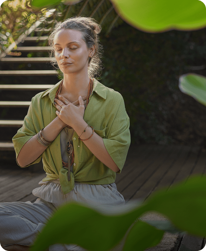 Woman meditating outdoors with closed eyes.