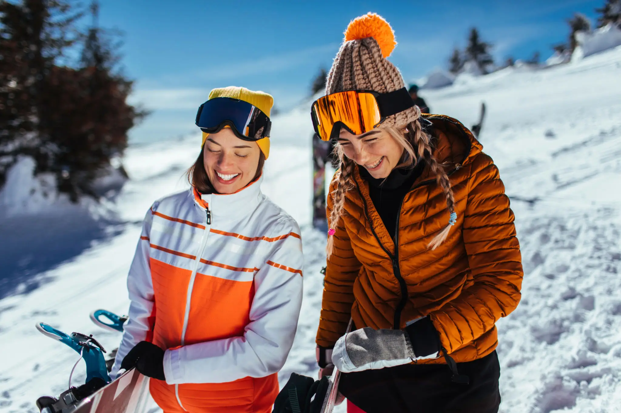 Two people in ski gear on snowy slope