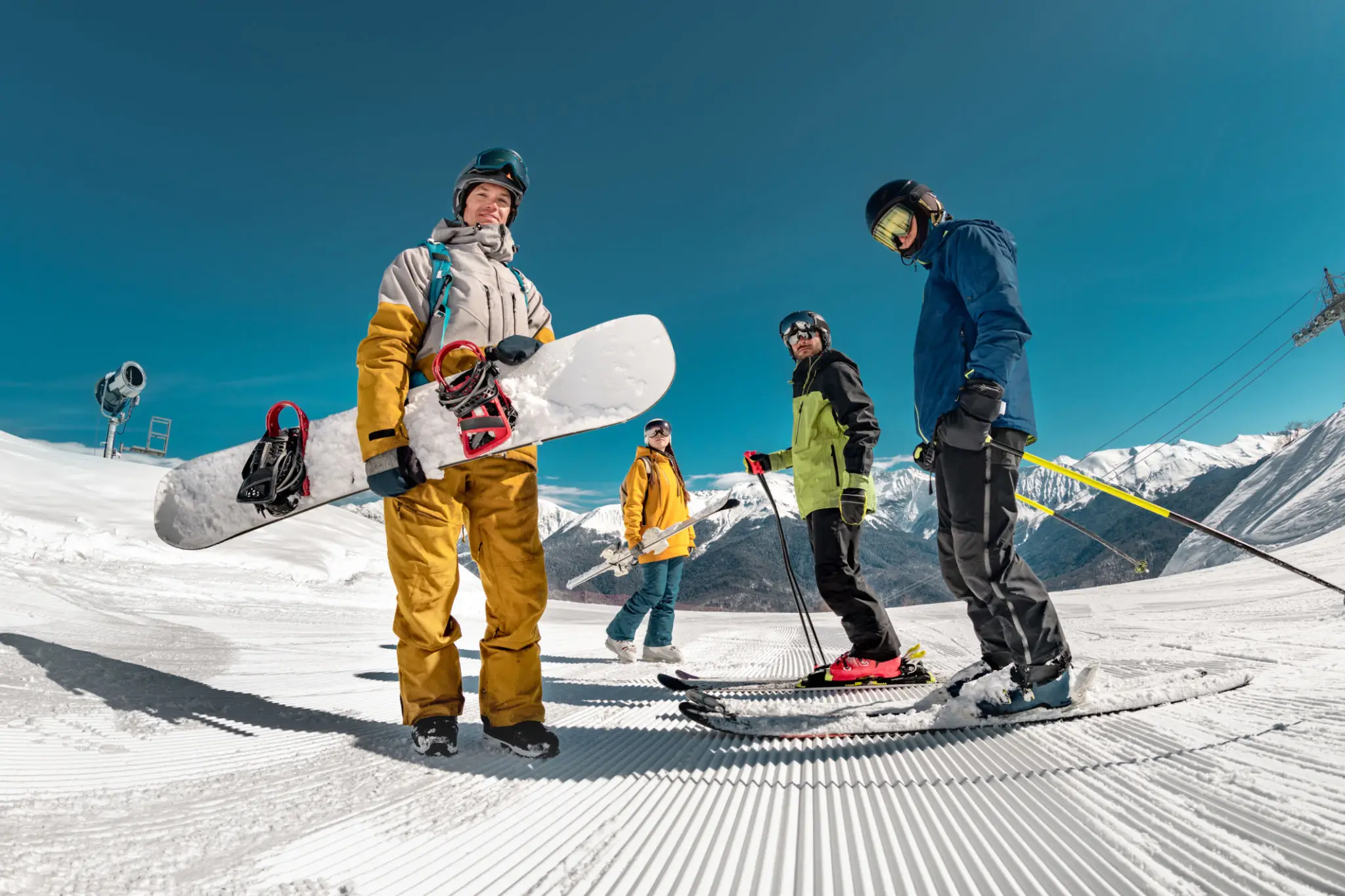 Skiers and snowboarders on snowy mountain slope